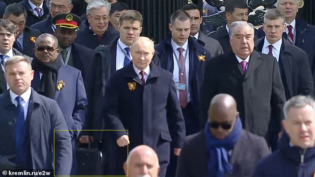 Putin is seen wearing an oversized button-up jacket, which could conceal body armor.  A member of his security team is seen holding a briefcase believed to be armor - or the nuclear football