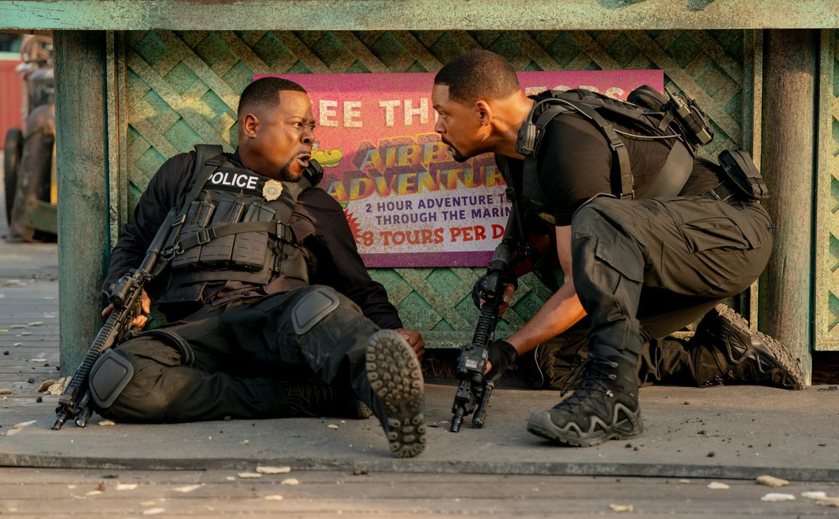 Detective Marcus Burnett lies against cover in SWAT gear as an equally rested Mike Lowrey gives him a pep talk in Bad Boys: Ride or Die