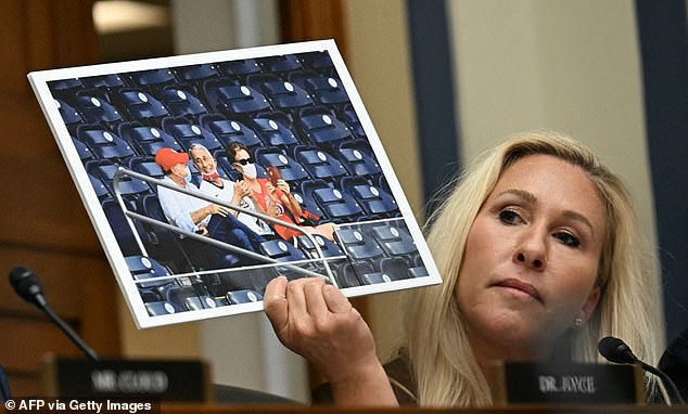 Rep. Marjorie Taylor Greene (R-Ga.) holds up a photo of Dr.  Fauci with his mask pulled under his chin at a baseball game during the pandemic during her questioning of the doctor during a hearing in the House of Representatives on Monday