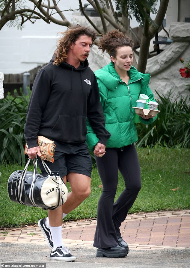 For the walk, Abbie cut a casual figure in black flared leggings, which she paired with a vibrant green padded jacket