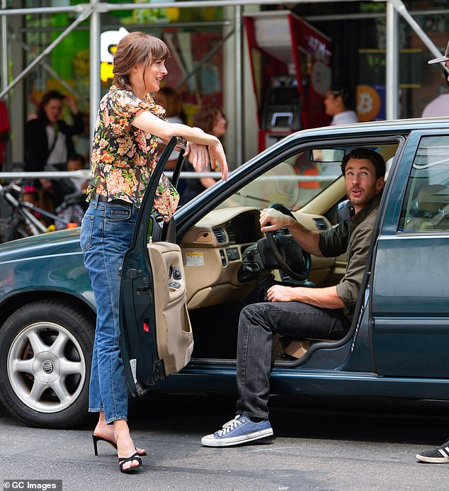 Dakota rested on the car door as the couple appeared to chat with a member of the crew