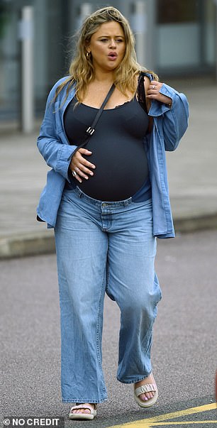 Emily looked radiant and radiant as she cradled her blossoming bump in her stylish denim ensemble