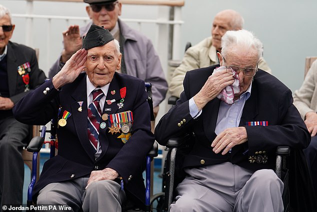 D-Day veteran Bernard Morgan (left), 100, from Crewe, salutes as veteran Jack Mortimer, 100, from Leeds, becomes emotional as he travels to France on a ferry yesterday