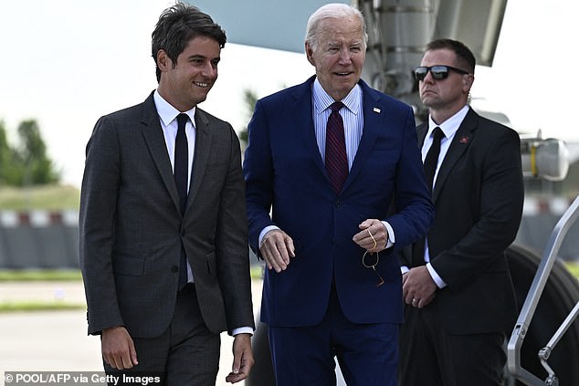 US President Joe Biden (C) is welcomed by French Prime Minister Gabriel Attal upon arrival at Paris Orly Airport near Paris on June 5