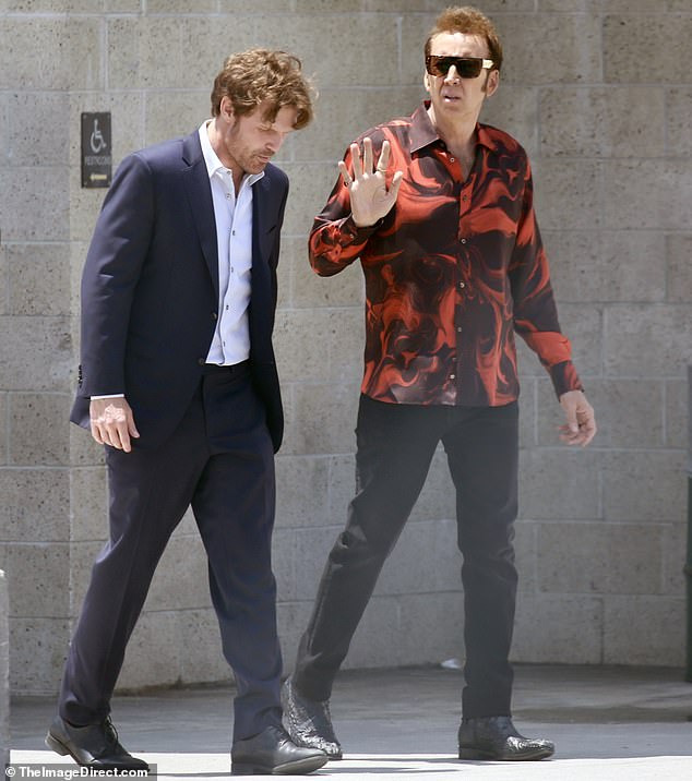 The 60-year-old had an outfit change for his scene with Scott Haze, this time opting for a red and maroon patterned shirt and black trousers.  His costar wore a two-piece dark blue suit and a white collared shirt