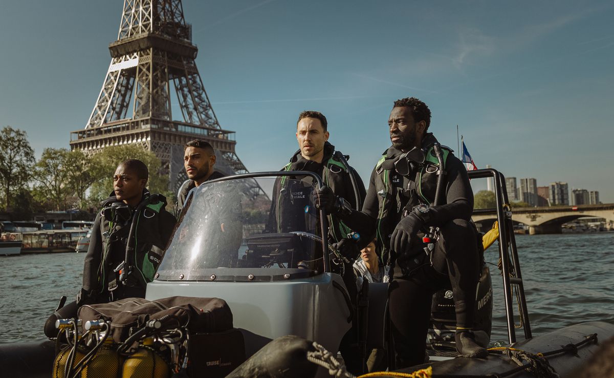 A group of River Brigade police officers take off along the Seine in front of the Eiffel Tower in Xavier Gens' Netflix shark thriller Under Paris