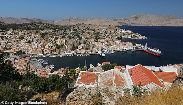 The Mail columnist is on break with his wife Clare on the Greek island of Symi (file photo), which lies off the coast of Rhodes