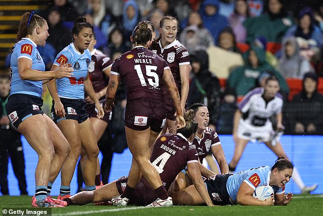 The Blues' Keeley Davis scores a try in the pouring rain during game two of the Women's State of Origin