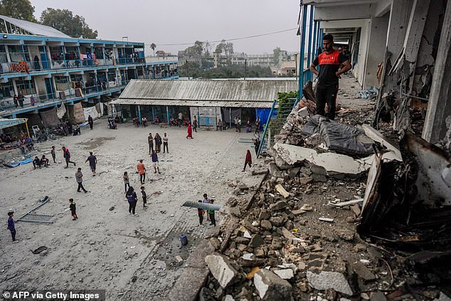 Palestinians check housing at a UN school where people affected by Israeli bombing have been displaced