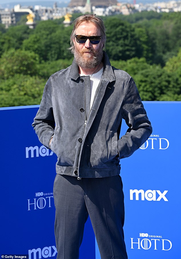 Rhys kept it casual for the photocall and wore a gray ensemble consisting of a suede bomber jacket, pleated trousers and a pair of trainers