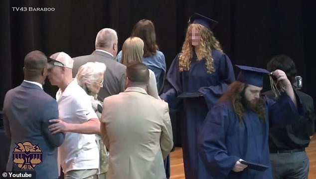 As his daughter pushed through a line of school officials and shook hands, Matt Eddy grabbed Superintendent Rainey Briggs by the arm and pushed him aside (far left)