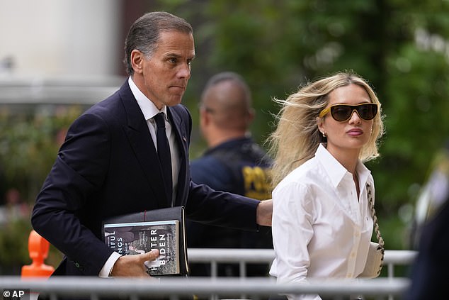 Hunter Biden, holding a copy of his memoir Beautiful Things, arrives in federal court in Wilmington, Delaware, with his wife Melissa Cohen Biden on Thursday, June 6, in the case surrounding claims that he lied on a form to get married in 2018 to buy a firearm