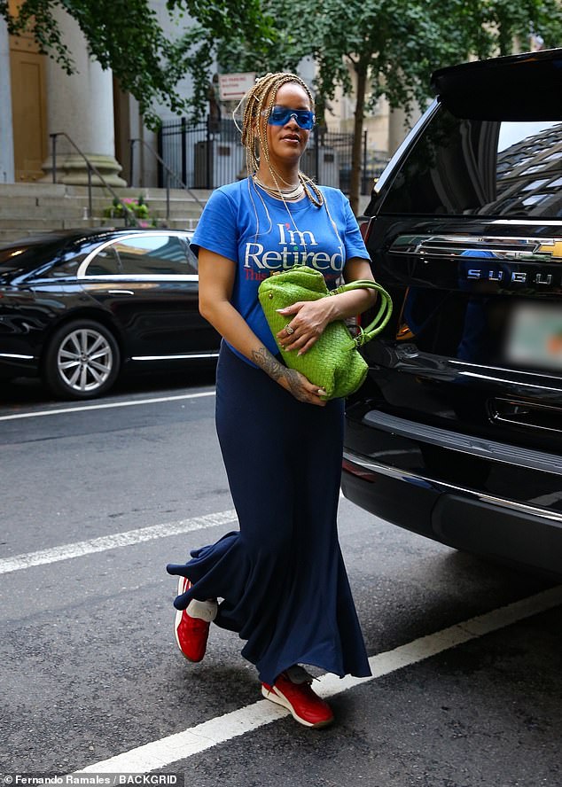 She paired the T-shirt with a navy blue mermaid-style skirt, red Puma sneakers and a bright green Bottega Veneta bag