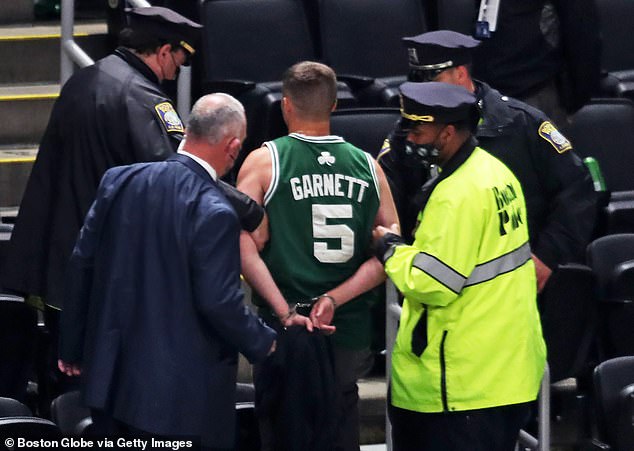 A man who allegedly threw a water bottle at Irving is escorted out by security