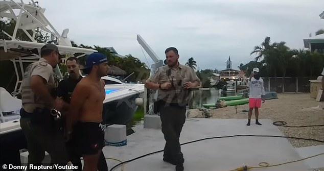 He was handcuffed after refusing to get off the boat and demanding that officers 