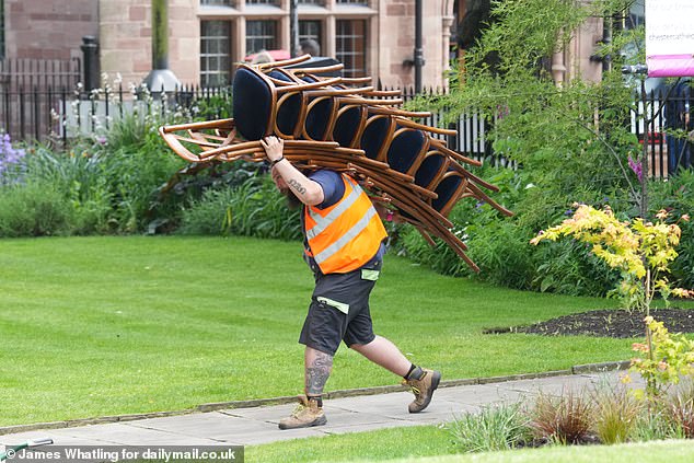 A workman carried a bundle of chairs through the garden of Chester Cathedral on Thursday, the day before the wedding