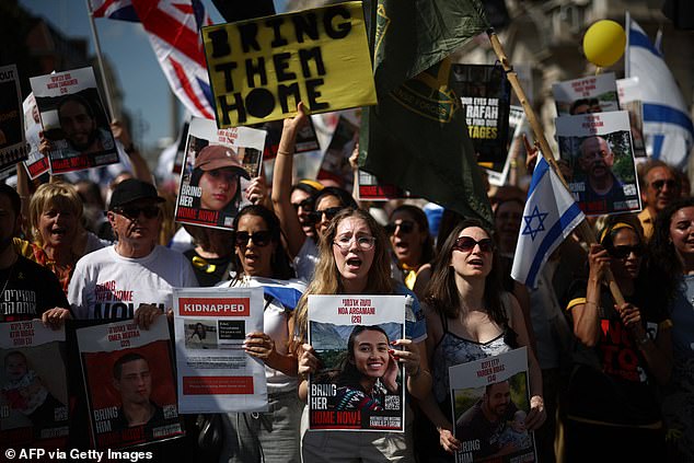 Protesters holding signs, including one of hostage Noa Argamani (center), take part in a "United we bring them home" March, in central London