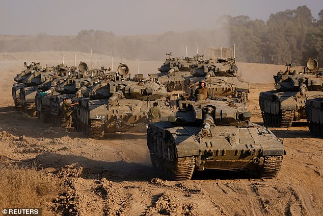 An Israeli soldier stands in a tank, amid the ongoing conflict between Israel and Hamas, near the Israel-Gaza border in Israel