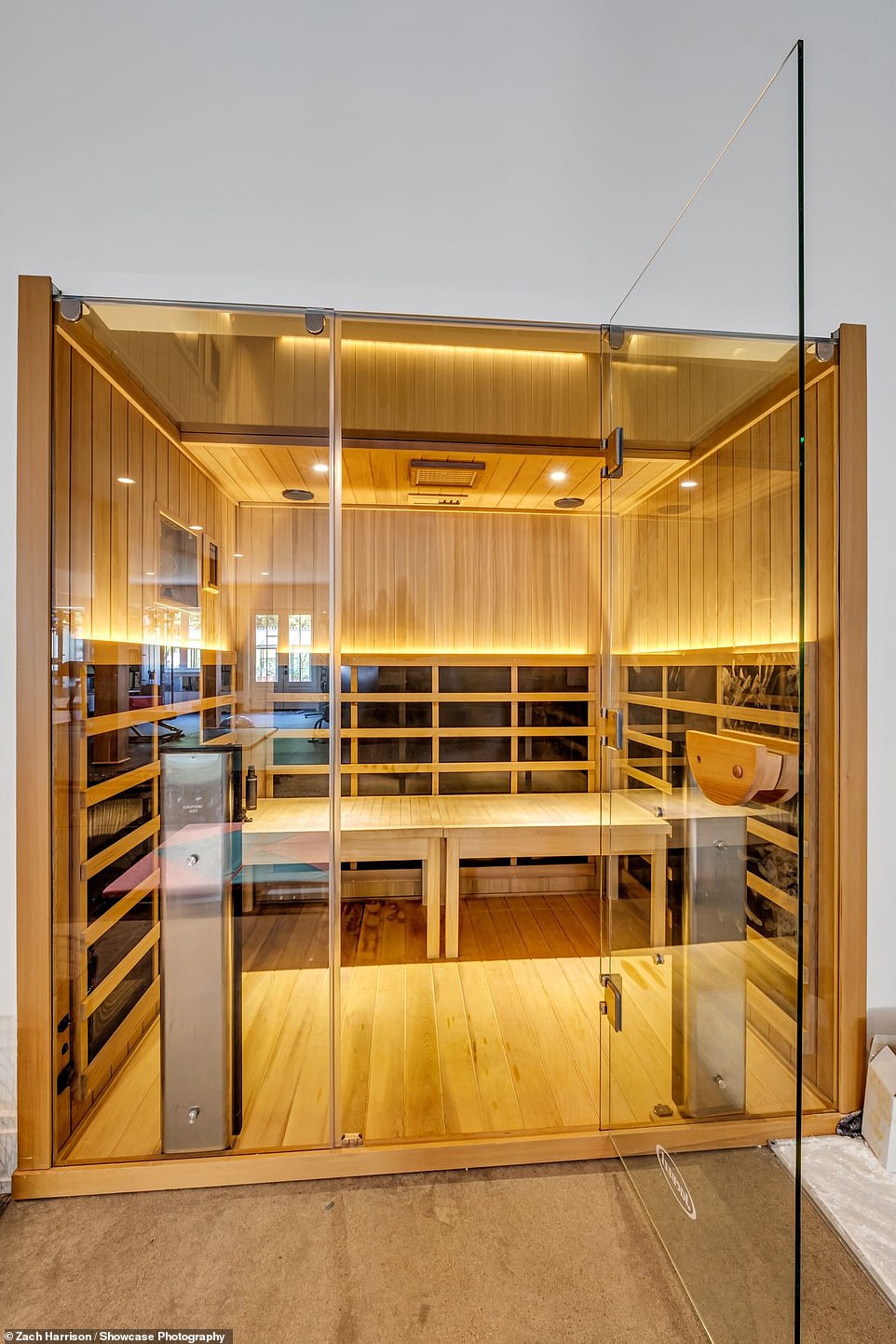 Her luxurious sauna features glass doors and wooden panels from floor to cell