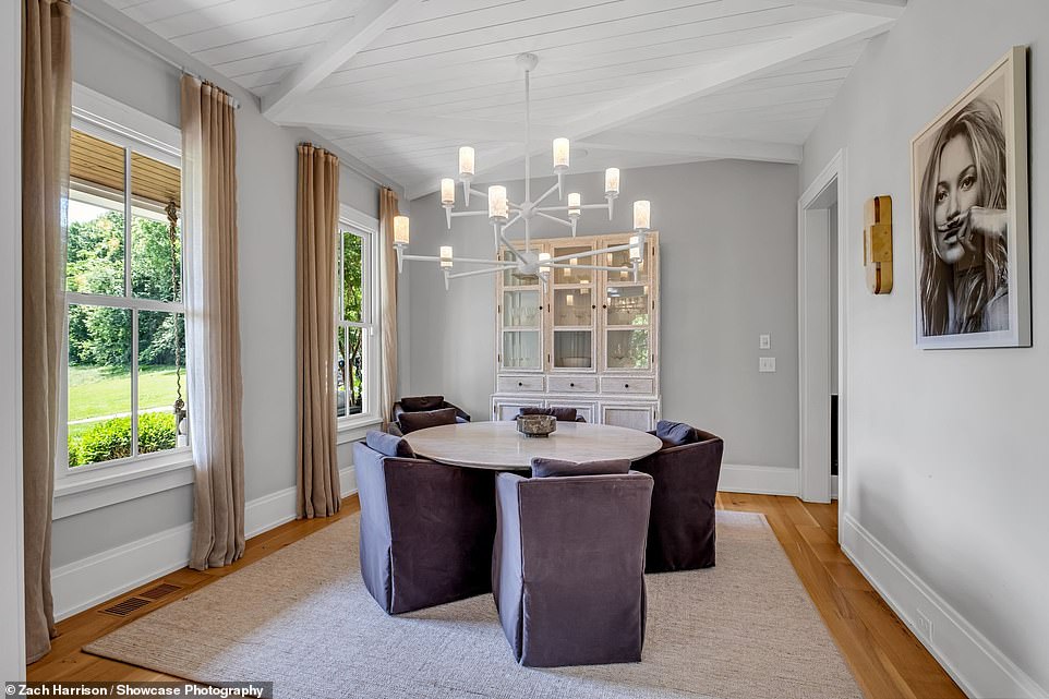 The dining room has large windows and a dramatic lighting fixture