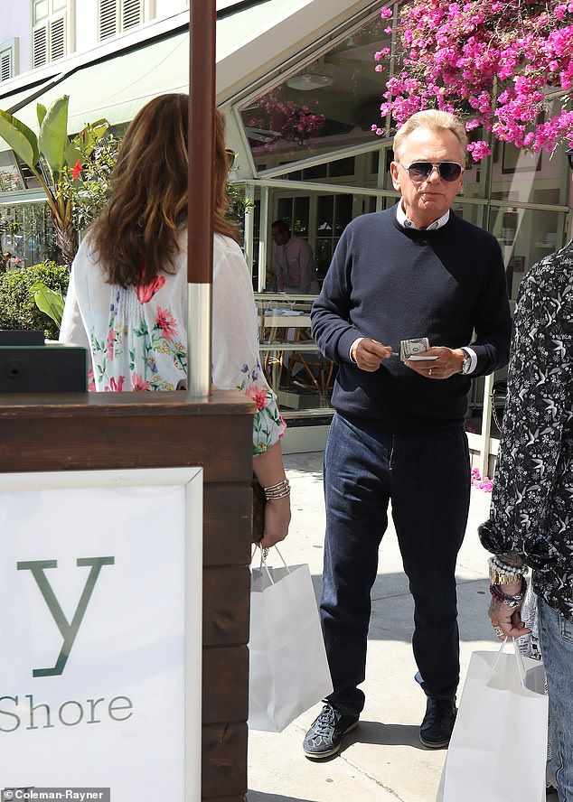 Sajak, known for his slick style, looked dapper in a navy blue crew neck sweater and jeans