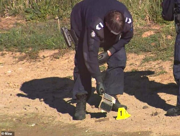 A police officer picks up a phone that appears to be almost identical to the one Samantha Murphy was using