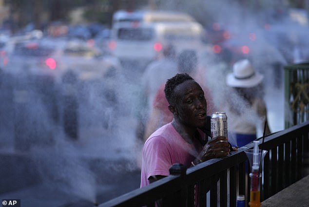 Cooling stations will be set up in Clark County where the public can find some relief during the day starting Wednesday.  (Image: A man is seen cooling off in misters along the Las Vegas Strip in July 2023)