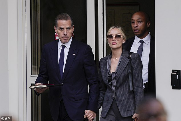 Hunter Biden (left) holds hands with his wife Melissa Cohen (right) as he leaves court Monday at the end of the opening day of his trial on criminal weapons charges in Wilmington, Delaware