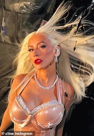 The 43-year-old singer shared a clip of herself showing off her slim figure and showing off her cleavage in a racy pink bodysuit with a latex corset bodice and sheer fishnet tights.