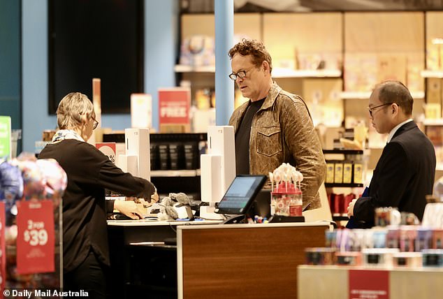 He then paid for his new items at the cash register, while the staff member stood nearby