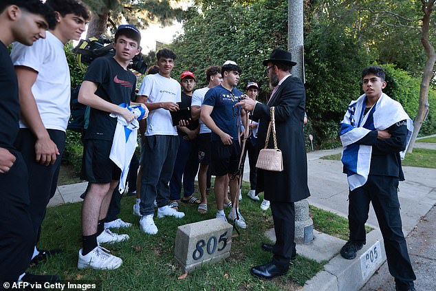 Supporters, some carrying Israeli flags, stand across the street from the mansion where Trump attended a fundraising dinner in Beverly Hills, California