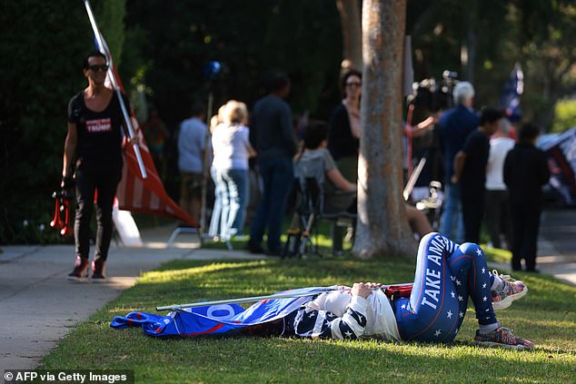 A supporter lies on the ground as Trump attends the fundraiser