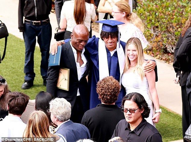 Seal looked dapper in a black suit and white shirt, while his girlfriend Laura turned heads in a white and gray striped midi dress