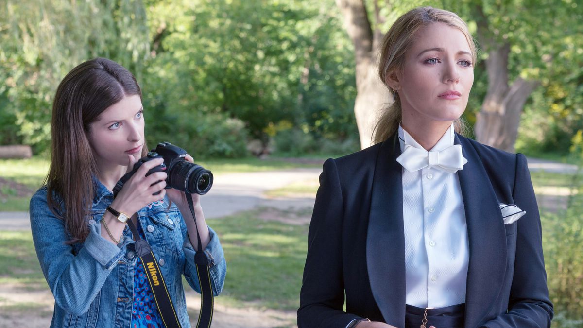 Anna Kendrick takes a photo of Blake Lively, wearing a suit with a white bow tie, in A Simple Favor