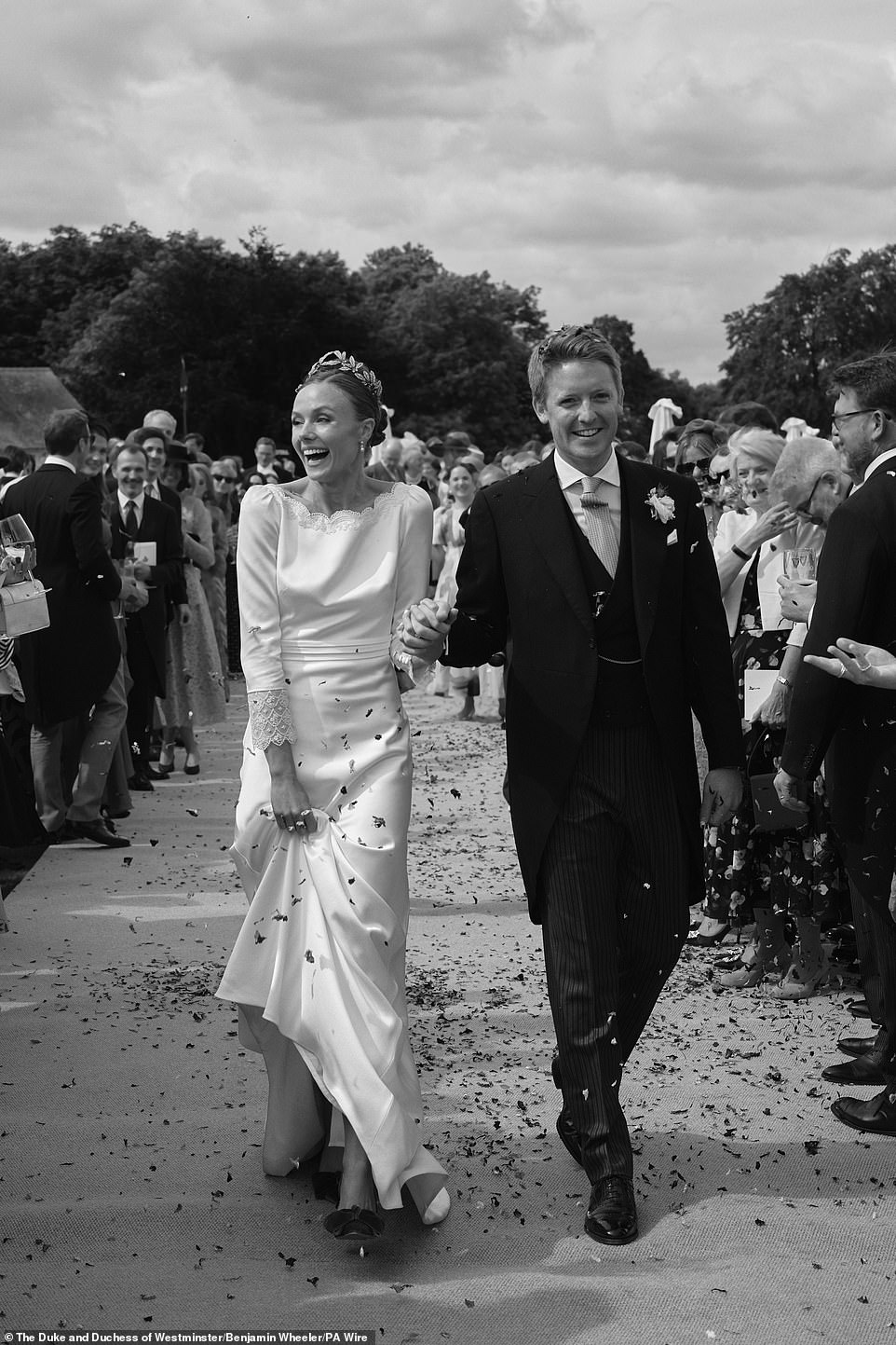 The happy couple walks away from the church surrounded by family