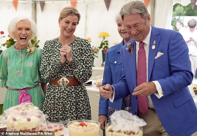 The royal family (pictured, centre) beams as they look at some of the sweet treats on display, accompanied by Dame Mary Berry (pictured, left) and Alan Titchmarsh (pictured, centre)