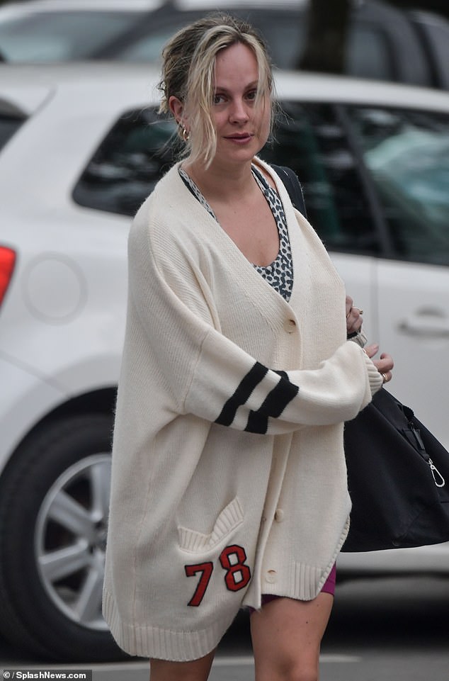 She wore a chunky knit cream cardigan with striped panels on the sleeves and the number 78 as she walked to her car.