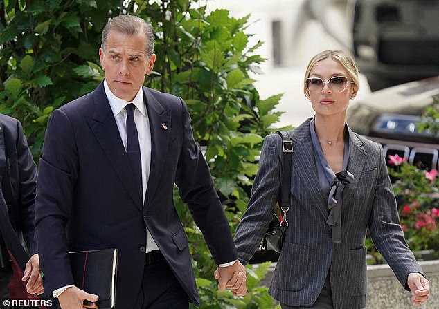 Hunter Biden (left) holds the hand of his wife Melissa Cohen (right) as he walks into court on Monday on the opening day of his trial on criminal weapons charges in Wilmington, Delaware