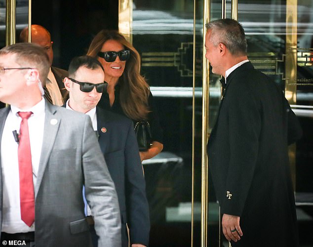 Melania beamed beneath her designer sunglasses as she left the building after her visit and was assisted by officers