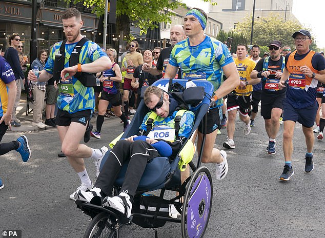 Inspiration: Kevin Sinfield pushes Rob, affected by motor neurone disease, in his wheelchair