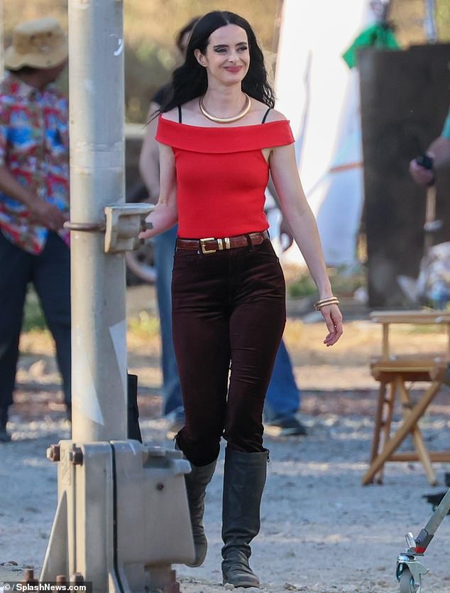 Ritter, 42, was first dressed in a red off-the-shoulder top with black bra straps visible.  Her character wore black jeans and boots.  The Jessica Jones star's makeup was camera-ready with bold eyeliner and a red lip, and her hair was styled straight