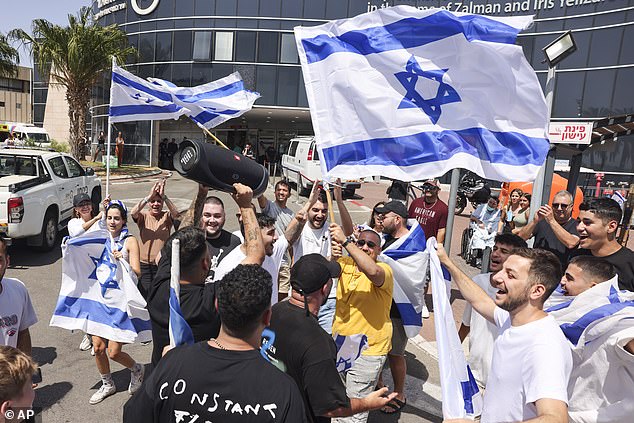 People wave Israeli flags as they celebrate after hostages kidnapped in a Hamas-led attack on October 7 were rescued from the Gaza Strip