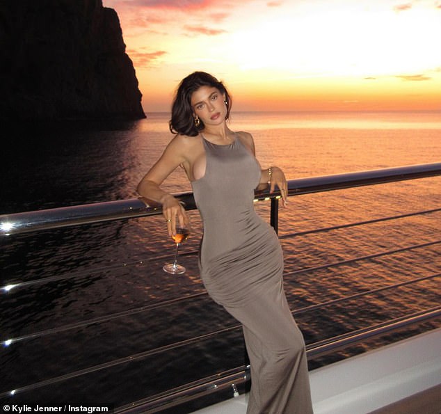 Kylie wore a brown-colored ensemble that clung to her body on another evening, stopping to take a photo with the colorful sunset in the background