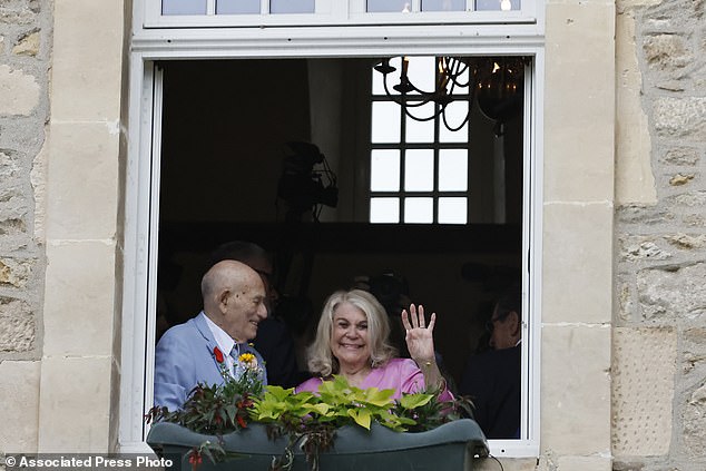 Terens, left, and Jeanne Swerlin, 96, smile from a window after celebrating their wedding at the town hall of Carentan-les-Marais, in Normandy, northwestern France, where they were married by the mayor