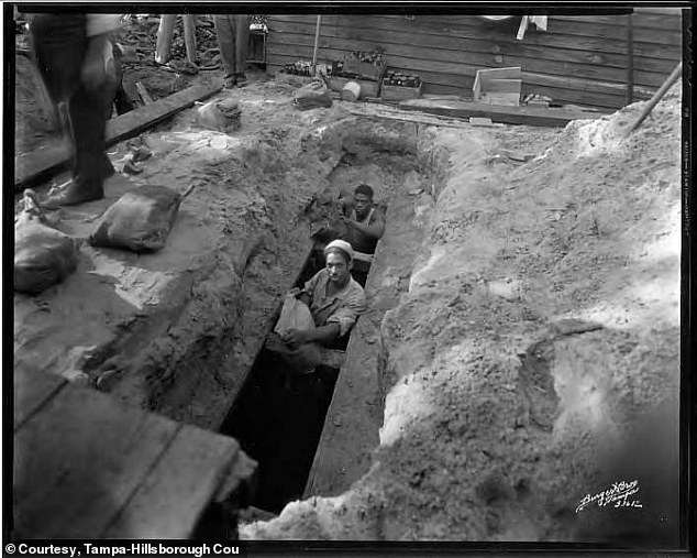 This undated photo shows federal authorities unearthing a buried whiskey stash in the backyard of an Ybor City home