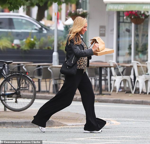 The lingerie model, 36, cut a stylish figure in black flared trousers and a statement leopard print shirt and shone under a cropped leather jacket