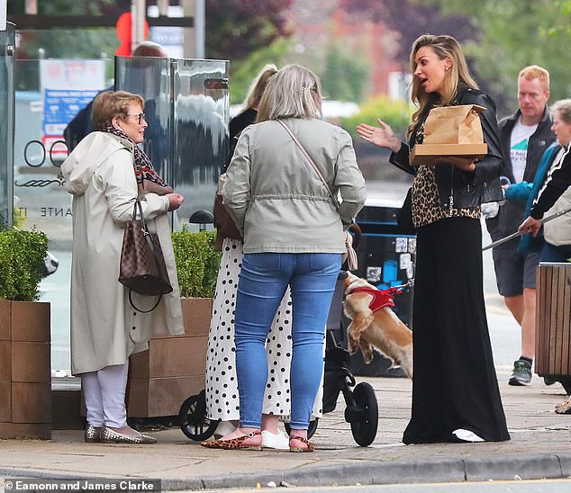 Zara added a pair of white trainers and carried a quilted black handbag, while her long hair was styled in perfect bouncy waves.