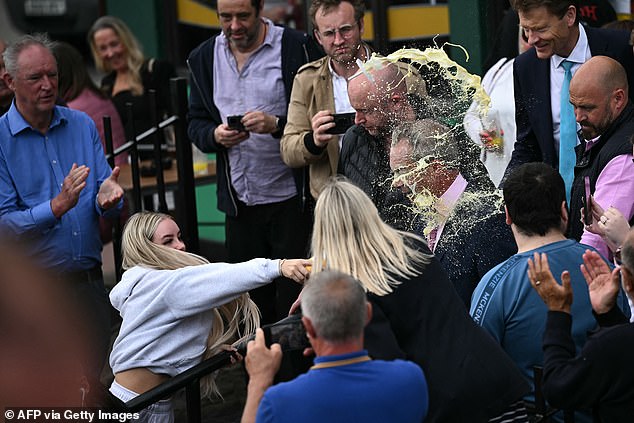 Mr Farage was flanked by heavy security as usual as he left a pub, but they could do nothing as the contents of what appeared to be a McDonald's cup were thrown at him.