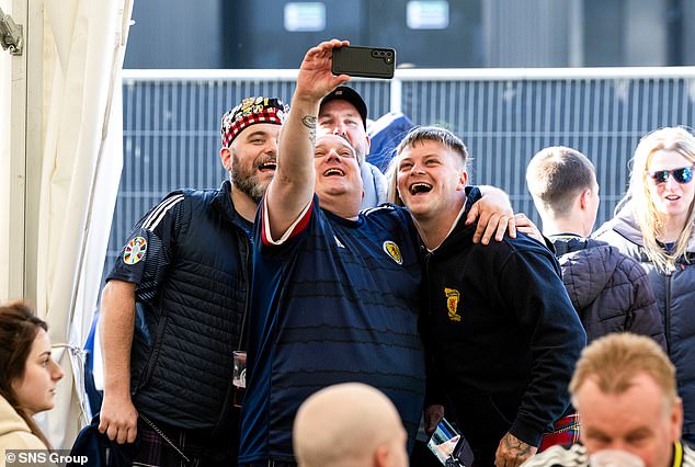 Scotland fans take a selfie in the Saltire Square fan zone before the match