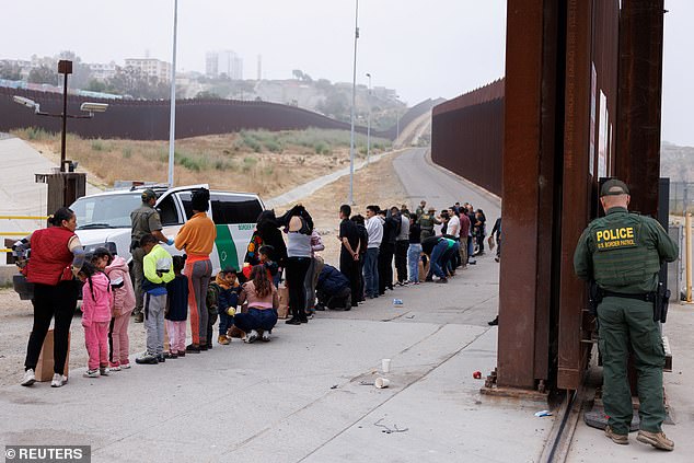 U.S. Border Patrol agents collect and sort migrants who gathered overnight between the primary and secondary border walls separating Mexico and the United States following the announcement of tough new restrictions imposed by President Biden